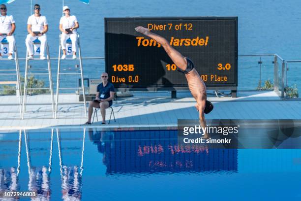 male diver diving in the swimming pool - risk scoring stock pictures, royalty-free photos & images