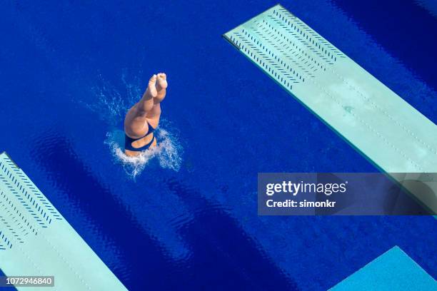 young woman diving in swimming pool - diving into water stock pictures, royalty-free photos & images