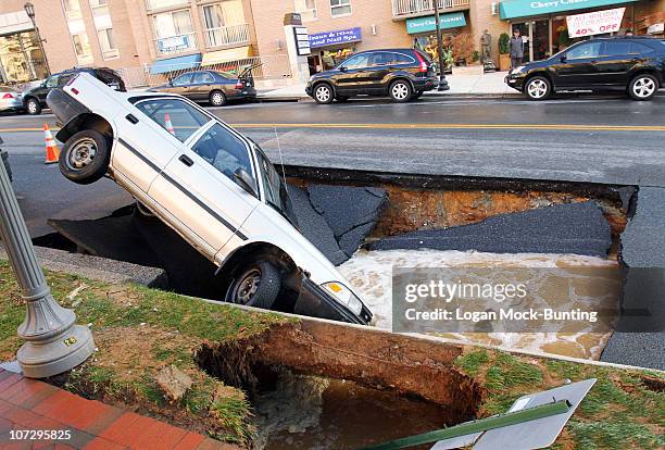 Car sits in a sinkhole caused by a broken water main, which collapsed part of Friendship Blvd. On December 3, 2010 in Chevy Chase, Maryland. No one...