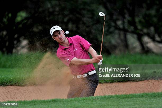 England's Ross Fisher plays shot out of a bunker on the 7th hole during the 2nd day of the Nedbank Golf Challenge in Sun City on December 03, 2010....