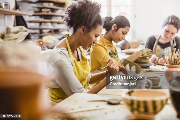 pequeño grupo de jóvenes, creación de cerámica - cerámica fotografías e imágenes de stock