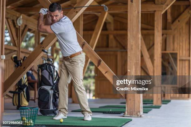 golf player taking a tee shot at the golf school - golf simulator stock pictures, royalty-free photos & images