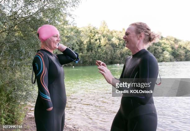 Women laughing while putting on swimming cap