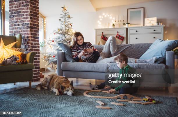 family celebrating christmas at home - christmas tree home stock pictures, royalty-free photos & images