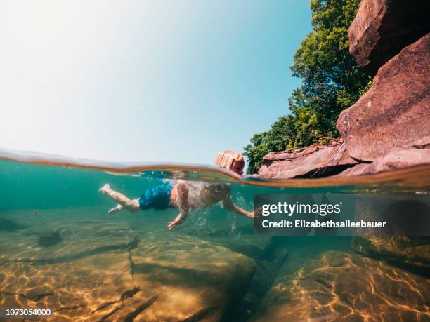 underwater shot of a boy swimming in lake superior, united states - lake superior stock-fotos und bilder