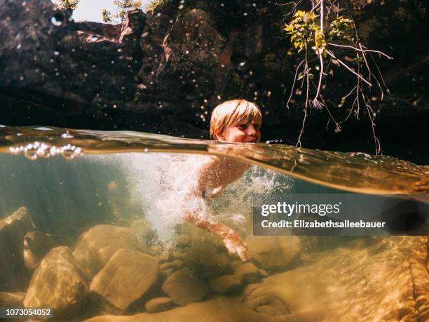 boy swimming in a lake, lake superior, united states - kid under water stock-fotos und bilder