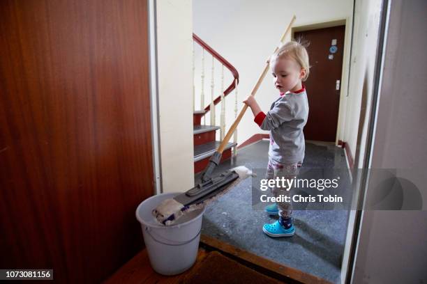 toddler mopping the floor in the stairwell - trabalho infantil imagens e fotografias de stock