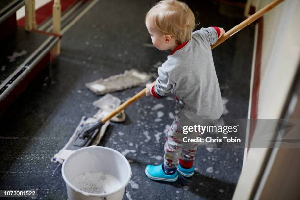 toddler mopping the stairwell - kinderarbeit stock-fotos und bilder