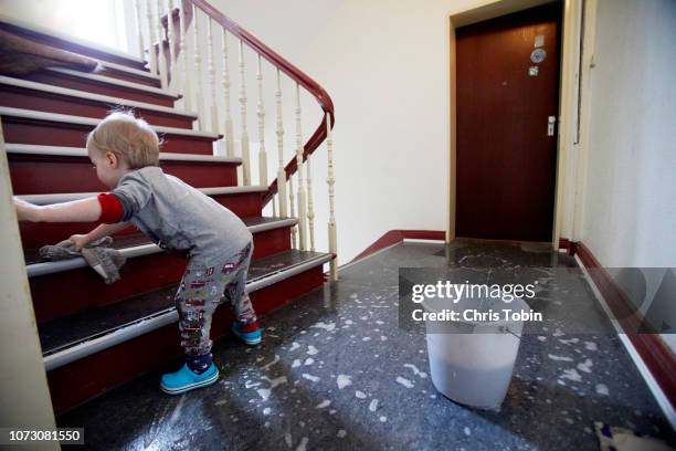 toddler wiping the stairs clean - child labor ストックフォトと画像