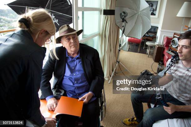 Behind-the-scenes view of Italian film director Bernardo Bertolucci during a photo shoot, Los Angeles, California, November 2013. He holds a copy of...