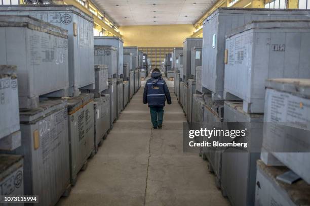 Worker walks through a warehouse storing crates containing supplementary equipment for nuclear reactors, originally destined for the suspended...