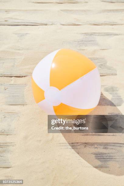 high angle view of boardwalk with sand and beach ball - wasserball stock-fotos und bilder