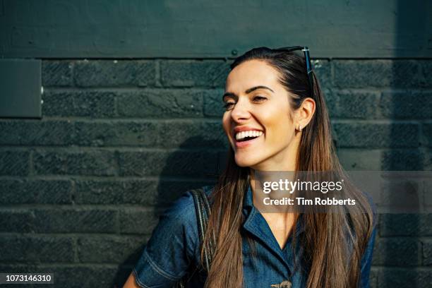 happy woman laughing off camera - cabello castaño fotografías e imágenes de stock