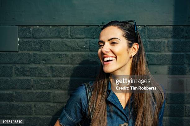 happy woman laughing off camera - pretty brunette woman stock pictures, royalty-free photos & images