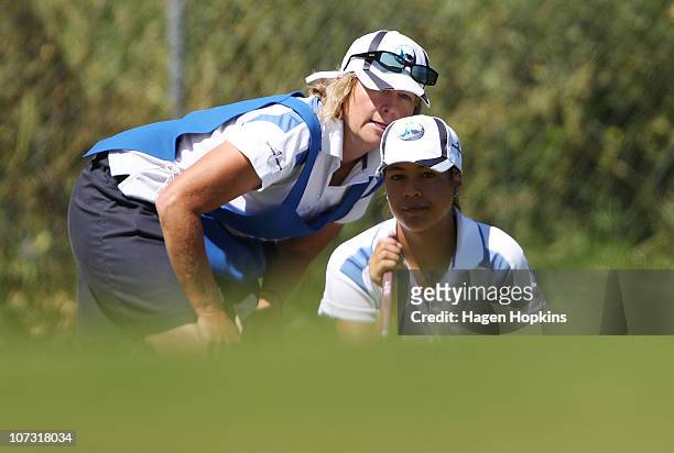 Brianna Maynard of Auckland lines up a putt with her caddy at the 14th hole during the semi-finals on the final day of the Women's Interprovincial...