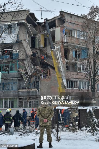 An employee monitoring a crane removes rubble from a partially destroyed five-storey building on the site of a gas explosion in the town of Fastiv,...