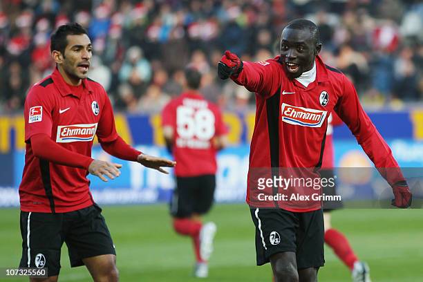 Papiss Demba Cisse of Freiburg celebrates his team's first goal with team mate Yacine Abdessadki during the Bundesliga match between SC Freiburg and...