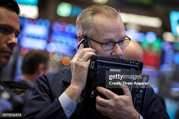 Traders and financial professionals work at the opening bell on the floor of the New York Stock Exchange , December 14, 2018 in New York City. The...