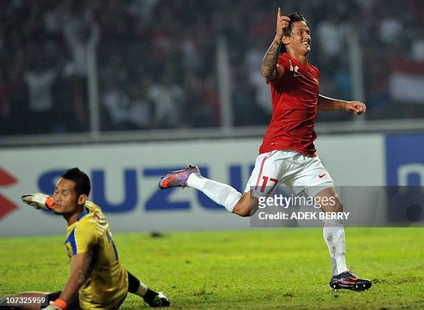 Indonesian player Irfan Bachdim celebrates a goal next to Laos's goal keeper Sengphachan Bounthisanh after scoring for his team during the...