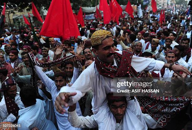 Pakistani people wearing traditional Sindhi caps and ajrak attire celebrate during Sindh Culural Day festival in Karachi on December 4, 2010. The day...