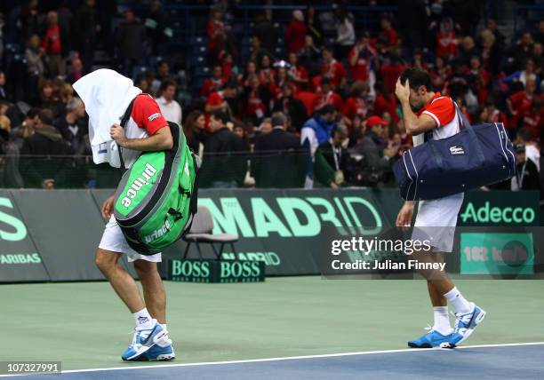 Nenad Zimonjic and Viktor Troicki of Serbia walk off after losing in five sets to Michael Llodra and Arnaud Clement of France in the doubles during...