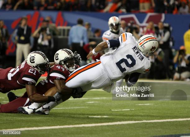 Quarterback Cam Newton of the Auburn Tigers dives in for a first quarter touchdown while safety DeVonte Holloman and linebacker Tony Straughter of...