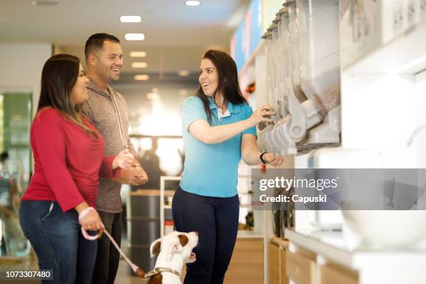 employee assisting customers at pet salon - pet shop stock pictures, royalty-free photos & images