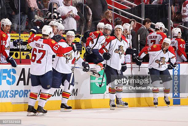 Steve Reinprecht, Shawn Matthias and Kenndal McArdle of the Florida Panthers celebrate with Michael Frolik after Frolik scored the game winning shoot...