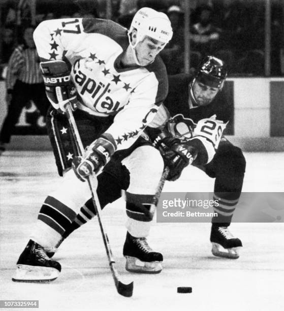 Washington's Mike Ridley and Pittsburgh forward Phil Bourque compete for the puck during first period action of their NHL game.
