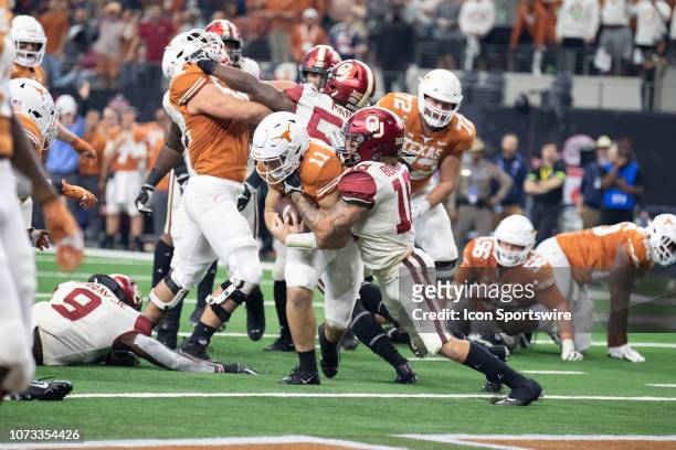 Texas Longhorns quarterback Sam Ehlinger fights his way into the end zone as Oklahoma Sooners linebacker Curtis Bolton tries to make the tackle...