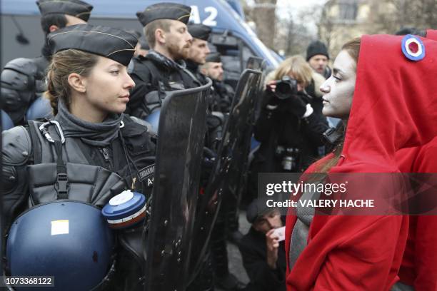 Woman dressed as "Marianne", the national symbol of the French Republic, stands in front a French riot policewoman during a demonstration on the...