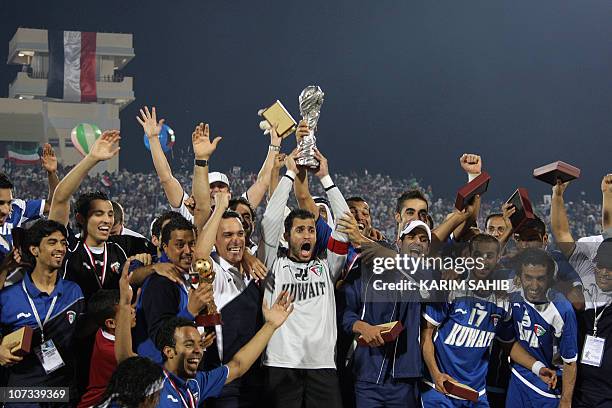 Kuwaiti players carry their trophy as they celebrate after winning the 20th Gulf Cup final football match against Saudi Arabia in the southern Yemeni...