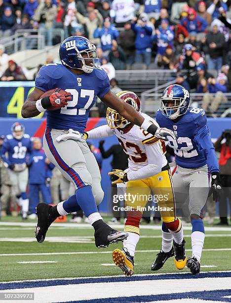 Brandon Jacobs of the New York Giants carries the ball past DeAngelo Hall of the Washington Redskins into the endzone for a first quarter touchdown...
