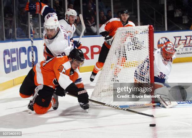 Nikolay Zherdev of the Philadelphia Flyers is tripped up by Jack Hillen of the New York Islanders at the Nassau Coliseum on December 5, 2010 in...