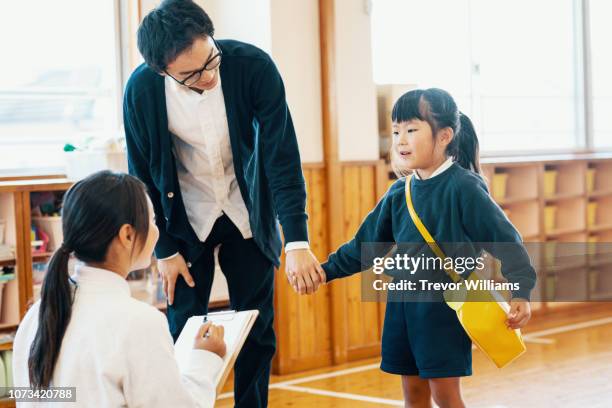 father dropping off young daughter at preschool - parent daughter school uniform stock pictures, royalty-free photos & images