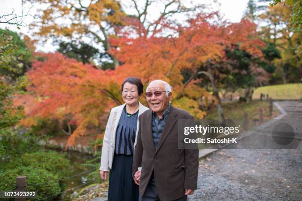 japanska äldre par promenader i höst lövverk - japanese senior couple bildbanksfoton och bilder