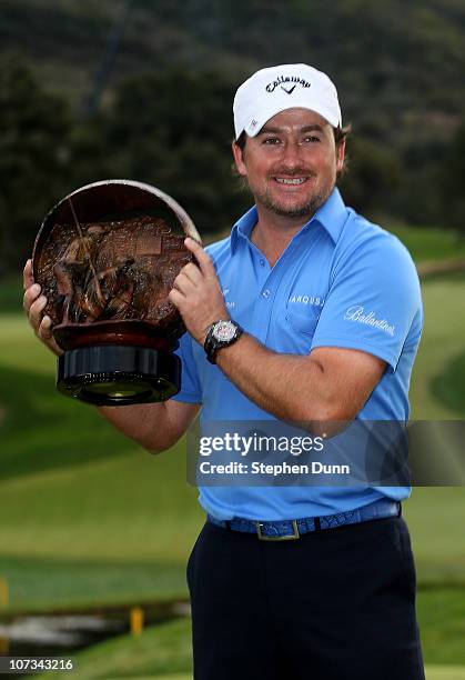 Graeme McDowell of Northern Ireland poses with the trophy after defeating Tiger Woods on the first playoff hole in the final round of the Chevron...
