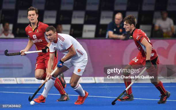 Harry Martin of England looks to break past Tom Boon and Antoine Kina of Belgium during the FIH Men's Hockey World Cup Semi-Final match between...