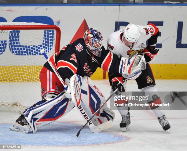 Henrik Lundqvist of the New York Rangers makes a glove save as Bobby Butler of the Ottawa Senators plays for the rebounded puck during the third...