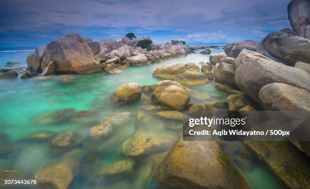 rocky beach - aqib widayatno stock pictures, royalty-free photos & images