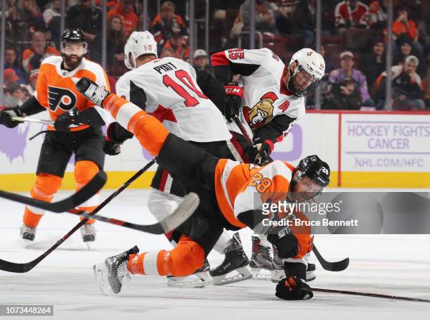 Claude Giroux of the Philadelphia Flyers is tripped up by Tom Pyatt of the Ottawa Senators during the second period at the Wells Fargo Center on...