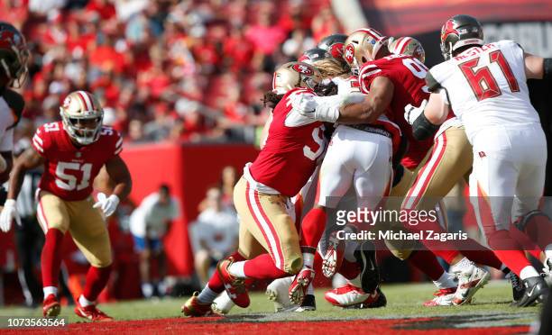 Sheldon Day and Arik Armstead of the San Francisco 49ers tackle Jacquizz Rodgers of the Tampa Bay Buccaneers during the game at Raymond James Stadium...