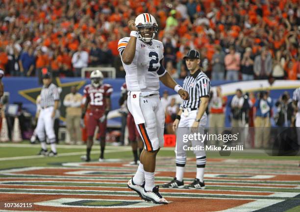 Quarterback Cam Newton of the Auburn Tigers celebrates after a touchdown during the 2010 SEC Championship against the South Carolina Gamecocks at...