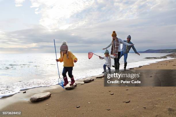 family walking on stepping stones on beach - cornwall england stock-fotos und bilder