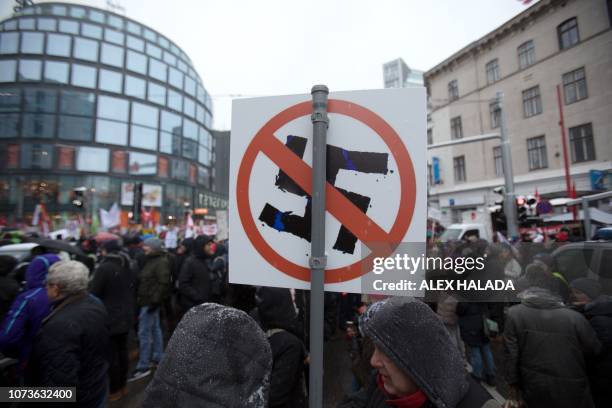 Protesters hold a sign with a crossed out swastika during a rally a year after the forming of a government by the conservative Oevp - FPOe parties on...