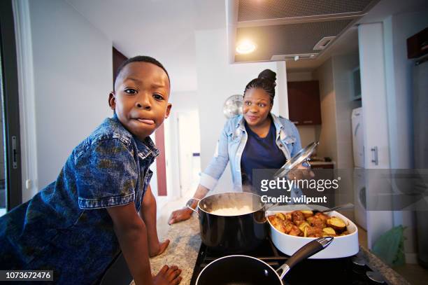 das sieht sehr lecker; jungen lecken lippen - black mother and child cooking stock-fotos und bilder
