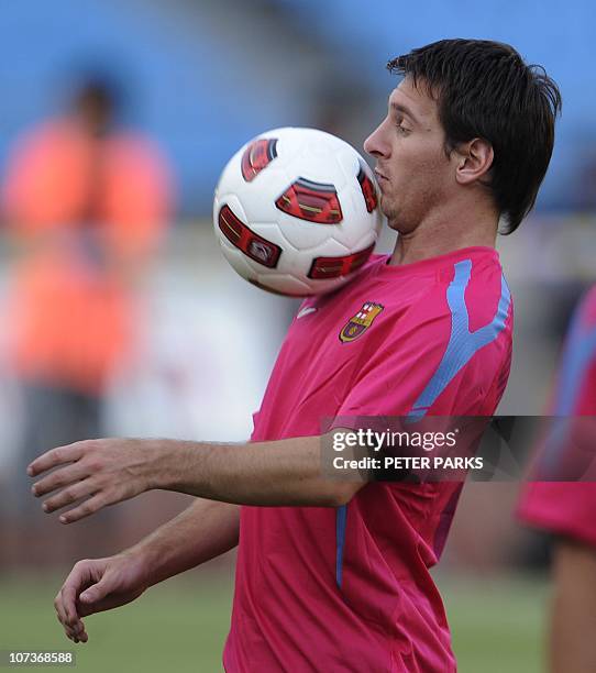 Barcelona's Argentinian player Lionel Messi eyes the ball during a light training session with teammates at the Worker's Stadium in Beijing on August...