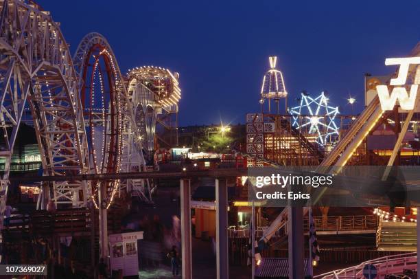 Night view of the illuminated rollercoaster and fun rides at the seaside resort of Blackpool, Lancashire, August 1983.