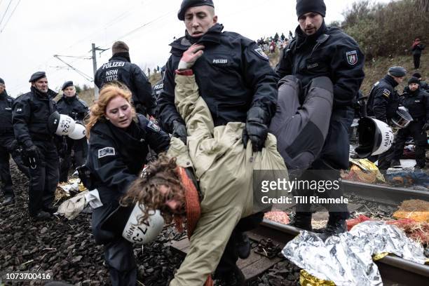 Police officers carry away an environmental activist of 'Ende Gelaende' , during the blockade of the rail track of the 'Hambach Bahn' to protest for...
