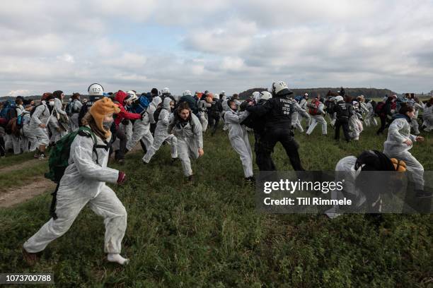 Police officers try to stop the march of environmental activists of 'Ende Gelaende' as they protest for the preservation of the ancient forest...